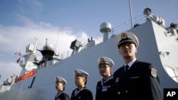 FILE - In this Dec. 7, 2016, photo, Chinese Navy officials stand in front of the ship Daqing, in San Diego.
