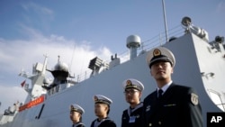 In this Dec. 7, 2016, photo, Chinese Navy officials stand in front of the ship Daqing, in San Diego.
