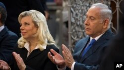 FILE - Israeli Prime Minister Benjamin Netanyahu, right, and his wife, Sara Netanyahu, applaud during their visit to a synagogue in Vilnius, Lithuania, Aug. 26, 2018.