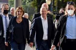 German Finance Minister, vice-chancellor and the Social Democratic SPD Party's candidate for chancellor Olaf Scholz (C) and his wife Britta Ernst (2nd L) arrive at the polling station in Potsdam, eastern Germany, Sept. 26, 2021.