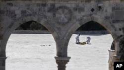 Expertos forenses de la policía israelí inspeccionan el cuerpo de un palestino en el lugar de un ataque en el complejo de la mezquita Al Aqsa en la ciudad vieja de Jerusalén, el viernes, 14 de julio de 2017.