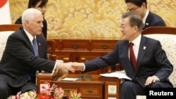 U.S. Vice President Mike Pence shakes hands with South Korean President Moon Jae-in after their meeting at the presidential office in Seoul, South Korea, Feb. 8, 2018.