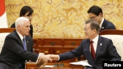 FILE - U.S. Vice President Mike Pence shakes hands with South Korean President Moon Jae-in after their meeting at the presidential office in Seoul, South Korea, Feb. 8, 2018.