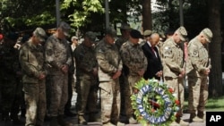 General John F. Campbell, commander of international forces in Afghanistan, second right, gives respect during a ceremony marking Memorial Day at the Resolute Support main headquarters in Kabul, Afghanistan, Monday, May 25, 2015.