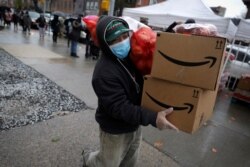 Ilustrasi. Seorang pria bermasker membawa paket makanan untuk penduduk yang membutuhkan di wilayah Brooklyn di kota New York City, New York, AS, 24 April , 2020. (Foto: Reuters/Mike Segar)