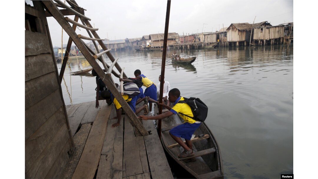 Students who attend a floating school arrive by canoe to school in the Makoko fishing community on the Lagos Lagoon, Nigeria, Feb. 29, 2016.