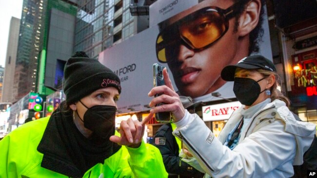A woman shows proof of vaccination against COVID-19 to enter Times Square for the New Year's Eve ball drop in New York, Dec. 31, 2021.