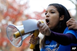 Rutgers University junior Carimer Andujar, of the Dominican Republic, shouts to a large crowd gathered to protest some of President-elect Donald Trump policies and to ask school officials to denounce his plans at Rutgers University, Nov. 15, 2016, in New Brunswick, N.J.