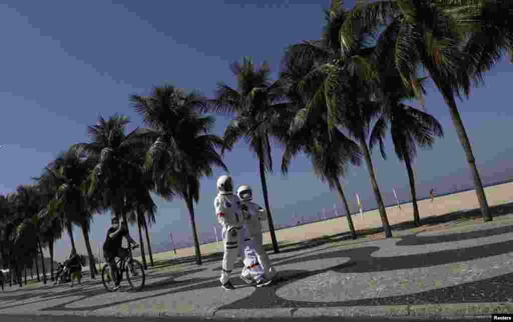 Tercio Galdino, 66, and his wife Aliceia, 65, wearing their protective &#39;space suits&#39;, walk on the sidewalk of Copacabana Beach amid the outbreak of the COVID-19 in Rio de Janeiro, Brazil, July 11, 2020.