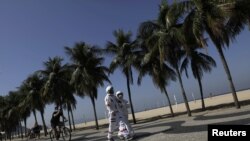 Tercio Galdino, 66, and his wife Aliceia, 65, wear their protective 'space suits' as they walk on the sidewalk of Copacabana Beach amid the outbreak of the coronavirus disease (COVID-19) in Rio de Janeiro, Brazil, July 11, 2020.