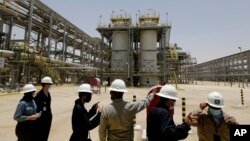 FILE - Saudi Aramco engineers and journalists look at the Hawiyah Natural Gas Liquids Recovery Plant, June 28, 2021, in Hawiyah, in the Eastern Province of Saudi Arabia.