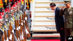 Cambodian Prime Minister Hun Sen bows to pay respects to the national flags of Cambodia and the Philippines shortly upon arrival at Clark International Airport in Clark, Pampanga province north of Manila, Philippines Saturday, Nov. 11, 2017.