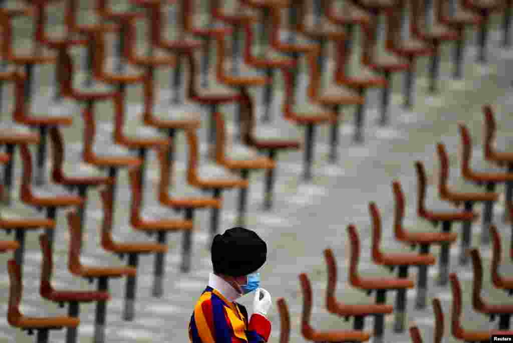 A Swiss guard fixes a face mask ahead of the weekly general audience held by Pope Francis, in Aula Paolo VI at the Vatican.