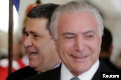 Paraguayan President Horacio Cartes smiles next to Brazil's President Michel Temer at the Mercosur trade bloc annual summit in Luque, Paraguay, June 18, 2018.