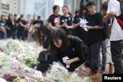 People pay their respects at the site where a man fell from a scaffolding at the Pacific Place complex while protesting against a proposed extradition bill, in Hong Kong, June 16, 2019.