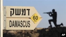 Sign showing distances to Damascus and a cut out of a soldier are seen at an army post from the 1967 war at Mt. Bental, Golan Heights, July 24, 2012.