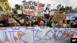 FILE - Protesters rally against the Dakota Access Pipeline behind the 128th Rose Parade in Pasadena, Calif., Jan. 2, 2017. The front lines of the battle against the $3.8 billion Dakota Access pipeline are shifting away from the dwindling encampment in North Dakota.