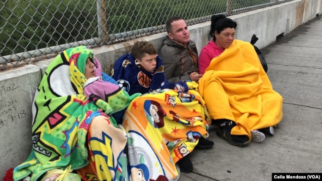 Migrants from Venezuela, Cuba and Guatemala wait at bridge between Matamoros, Mexico and Brownsville, Texas for immigration officials to allow them to turn themselves in and ask for asylum in U.S., Nov. 12, 2018.