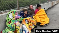 Migrants from Venezuela, Cuba and Guatemala wait at bridge between Matamoros, Mexico and Brownsville, Texas for immigration officials to allow them to turn themselves in and ask for asylum, Nov. 12, 2018.