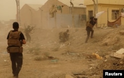 FILE - Iraqi security forces defend their headquarters against attacks by Islamic State extremists in the eastern part of Ramadi in Anbar province, May 14, 2015.