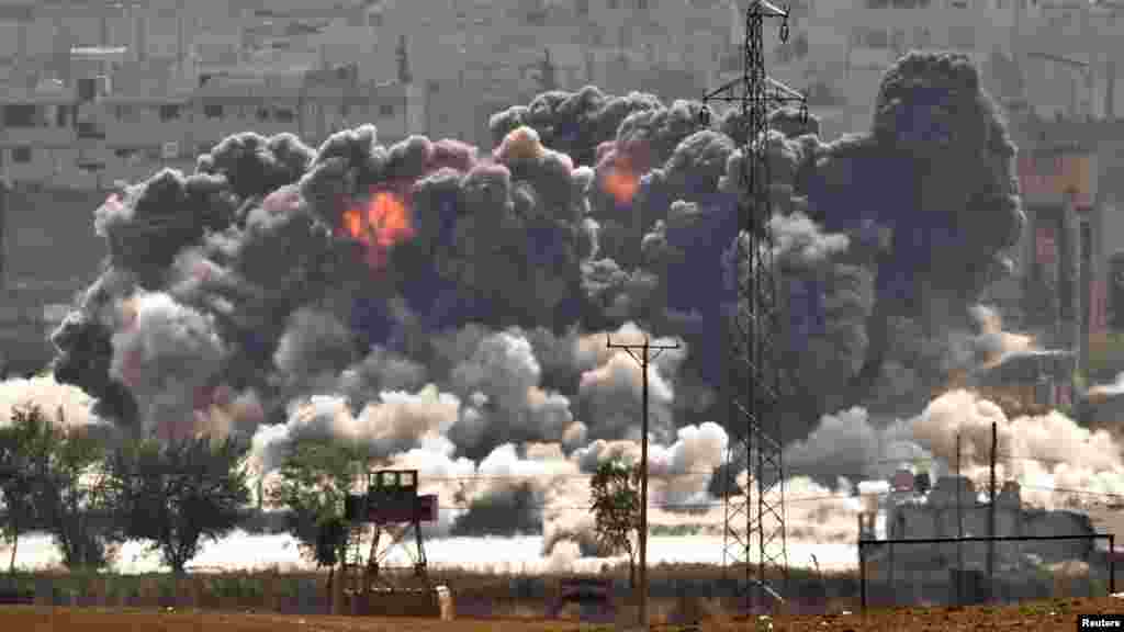 Smoke and flames rise from an Islamic State fighters' position in the town of Kobani during airstrikes by the US led coalition seen from the outskirts of Suruc, near the Turkey-Syria border, Oct. 28, 2014. 