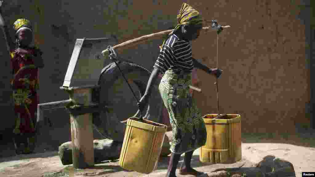 A girl transports water after fetching from a borehole in Bichi village near Kano.