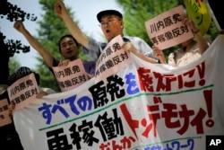 Protesters shout slogans against a Japanese nuclear plant that won preliminary approval for meeting stringent post-Fukushima safety requirements, near the Diet building in Tokyo, July 16, 2014.