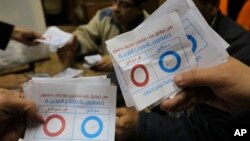 Nhân viên phụ trách bầu cử đếm các lá phiếu được đánh dấu 'đồng ý,' trong cuộc trưng cầu dân ý về bản hiến pháp, tại 1 phòng phiếu ở thủ đô Cairo, 15/1/14