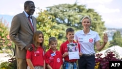 IFRC goodwill ambassador Princess Charlene of Monaco (R) and IFRC Secretary General Elhadj As Sy (L) pose with children during the launch of World First Aid Day 2016 on Sept. 9, 2016 at the UN Office in Geneva