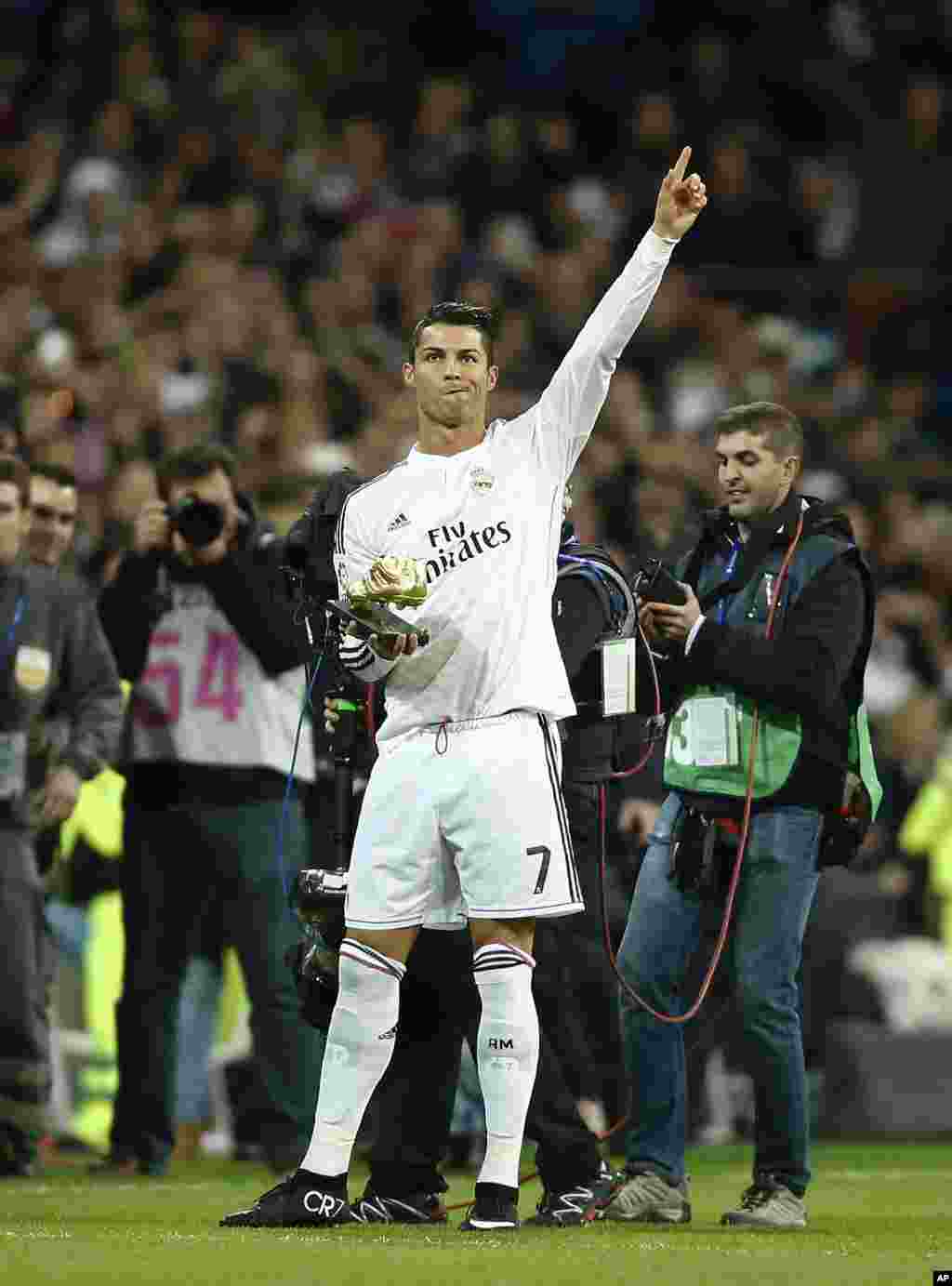 Cristiano Ronaldo, tenant un trophée Soulier d&#39;Or 2013-2014, remercie la foule lors d&#39;un match de football de la Liga espagnole entre le Rayo Vallecano et le Real de Madrid au stade Santiago Bernabeu à Madrid, Espagne, le samedi 8 novembre 2014.