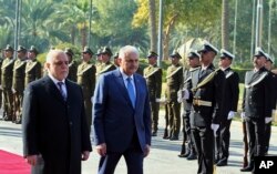 Iraq's Prime Minister Haider al-Abadi, left, and Turkish Prime Minister Binali Yildirim inspect an honor guard during a welcome ceremony in Baghdad, Iraq, Jan. 7, 2017.