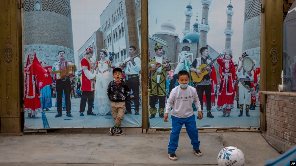 孩子在新疆乌鲁木齐街头踢足球。（2021年4月21日）(photo:VOA)