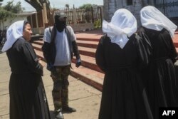 A supporter of under-pressure Nicaraguan President Daniel Ortega talks to nuns outside the San Sebastian Basilica in Diriamba, Nicaragua, July 9, 2018.