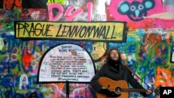 A street musician plays a guitar at Prague's "Lennon Wall", which under the former communist regime was a place where young people gathered to express their hope for freedom.