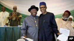Nigeria's President Goodluck Jonathan and opposition candidate Gen. Muhammadu Buhari hug after signing a renewal of their pledge to hold peaceful "free, fair, and credible" elections, March 26, 2015.