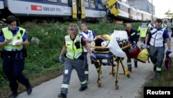 Swiss rescue workers wheel a wounded person on a stretcher after two regional trains crashed head on near Granges-Pres-Marnand near Payerne in western Switzerland, July 29, 2013. 