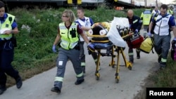 Des pompiers transportent sur des civières les victimes d’un accident près de Payerne, Suisse, 29 juillet 2013.