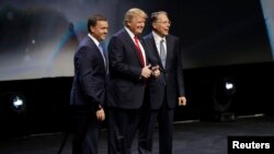 FILE - Republican presidential candidate Donald Trump is introduced by National Rifle Association executive director Chris W. Cox (L) and NRA executive vice president Wayne LaPierre (R), as Trump takes the stage to speak at the NRA convention, May 20, 201