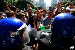 High school students face riot police officers as they protest in Algiers, Algeria, March 12, 2019.