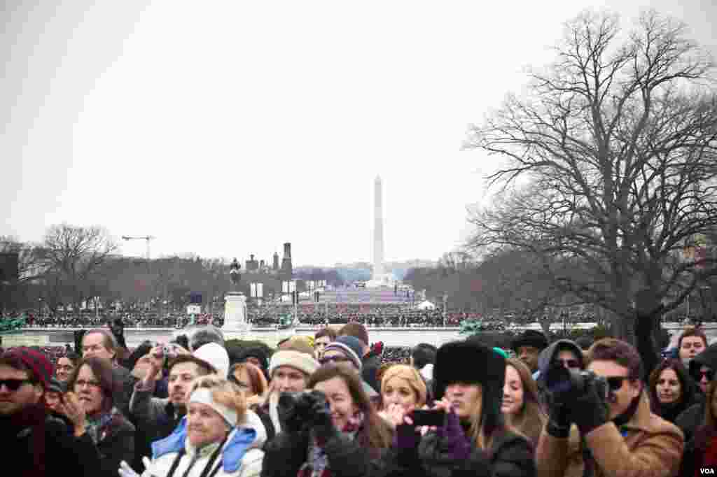 Members of the crowd watch President Barack Obama's Inauguration Day speech in Washington, D.C., January 21, 2013. (Alison Klein/VOA)