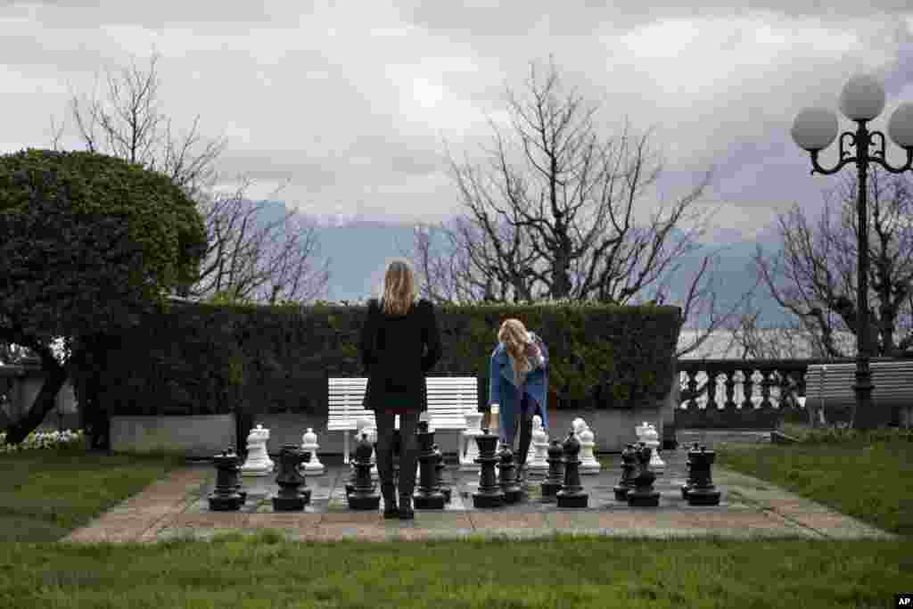 Russian journalists play a game of chess in the Beau Rivage Palace Hotel courtyard in Lausanne, Switzerland, April 1, 2015.