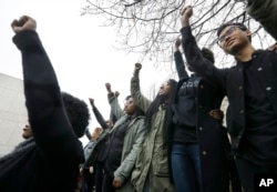 FILE - Students at Boston College raise their arms during a solidarity demonstration on the school's campus, Thursday, Nov. 12, 2015, in Newton, Mass.