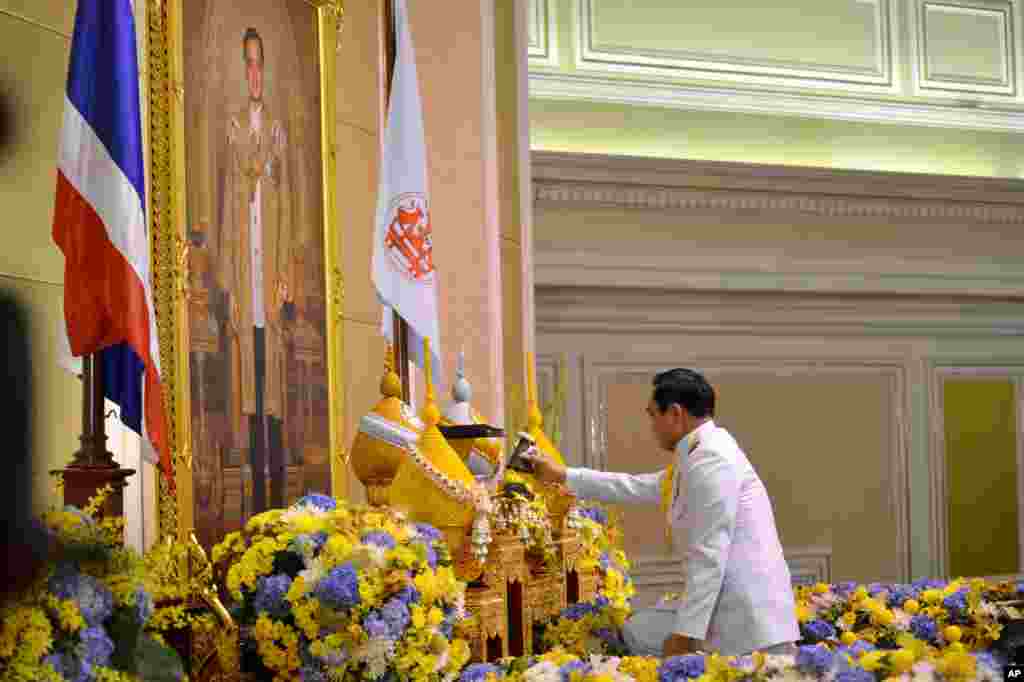 Gen. Prayuth Chan-ocha opens a container before he accepts a royal endorsement certifying his appointment as the country&#39;s 29th premier, in front of the portrait of King Bhumibol Adulyadej in Bangkok, Aug. 25, 2014.