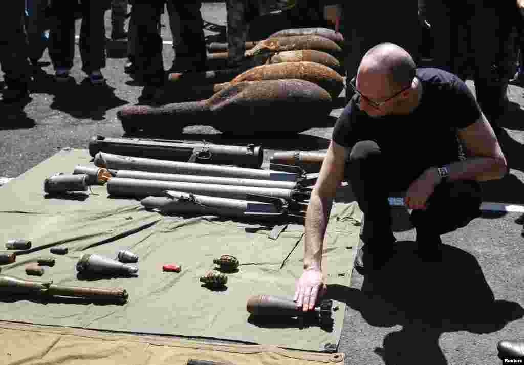 Prime Minister Arseny Yatseniuk inspects weapons seized from pro-Russian separatists as he meets with Ukrainian servicemen, Slovyansk, July 16, 2014.