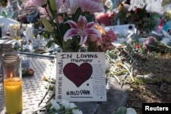 Flowers and mementoes are seen the day students and parents came for voluntary campus orientation at the Marjory Stoneman Douglas High School, Feb. 25, 2018. The school reopens Wednesday, following the Valentine's Day mass shooting in Parkland, Florida.