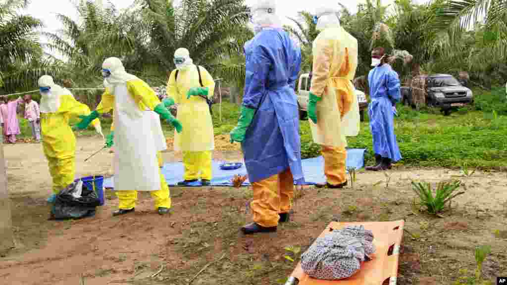 Des agents de la santé, vêtus d&rsquo;équipement de protection contre le virus Ebola, transportent sur une civière la dépouille d&#39;un enfant nouveau-né suspecté mort après avoir contracté l&rsquo;épidémie, à Dubreka, Guinée, le 19 juin 2015