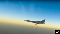 FILE - In this frame grab from video provided by the Russian Defense Ministry Press Service, Russian long-range bomber Tu-22M3 flies during a strike above an undisclosed location in Syria, Aug. 14, 2015. 