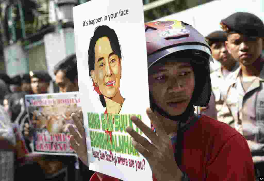 Seorang aktivis mengusung poster bergambar pemimpin oposisi Myanmar Aung San Suu Kyi pada sebuah aksi protes menuntut diakhirinya kekerasan terhadap etnis Rohingya, di luar Kedutaan Besar Myanmar di Jakarta, Indonesia.