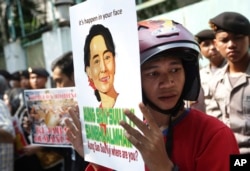 FILE - An activist displays a poster of the portrait of Myanmar's opposition leader Aung San Suu Kyi during a protest demanding an end to the violence against ethnic Rohingyas in Rakhine State, outside the Embassy of Myanmar in Jakarta, Indonesia, May 29, 2015.