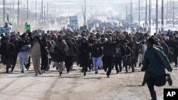 Afghan demonstrators run as they shout anti-US slogans during a protest against Koran desecration in Kabul, February 23, 2012.
